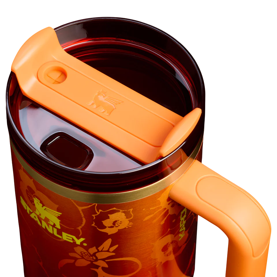 Stanley x Karol G 40 oz Quencher Tumbler in ruby red with floral artwork and pineapple straw topper next to its orange collector box - View 4 | Clistos