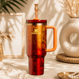Stanley x Karol G 40 oz Quencher Tumbler in ruby red with floral artwork and pineapple straw topper next to its orange collector box - View 7 | Clistos