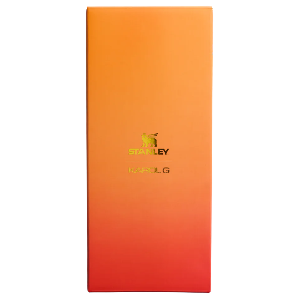 Stanley x Karol G 40 oz Quencher Tumbler in ruby red with floral artwork and pineapple straw topper next to its orange collector box - View 6 | Clistos