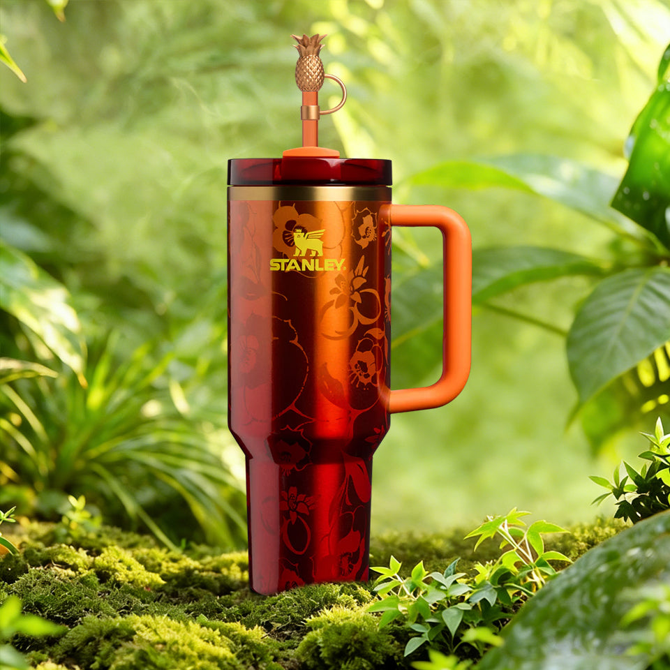 Stanley x Karol G 40 oz Quencher Tumbler in ruby red with floral artwork and pineapple straw topper next to its orange collector box - View 2 | Clistos